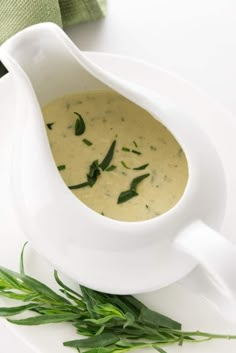 a white bowl filled with soup on top of a plate next to a green napkin