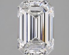 an emerald cut diamond on a gray background with the center stone in yellow and white