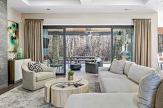 a living room with couches, chairs and tables in front of sliding glass doors