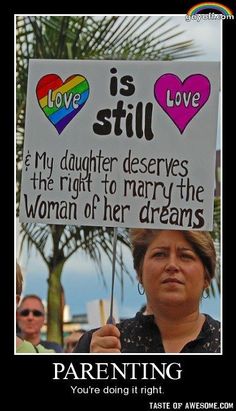 a woman holding a sign that says love is still and my daughter deserves the right to marry the woman of her dreams