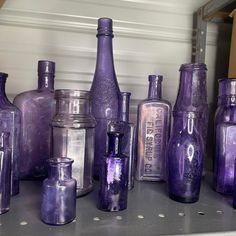 purple glass bottles are lined up on the shelf