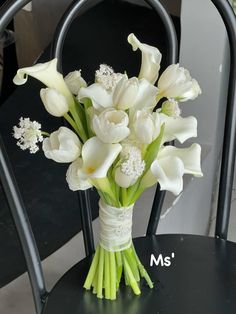 a bouquet of white flowers sitting on top of a black chair