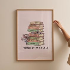 a woman is holding up a poster with books stacked on top of each other, which reads women of the bible