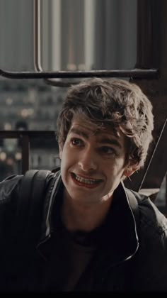 a young man with braces is smiling at the camera while wearing a black shirt