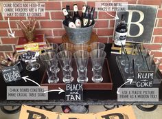 a table topped with lots of glasses next to a sign and some signs on it