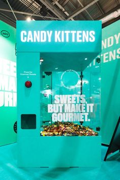 a candy kiosk sitting on top of a blue floor next to a green wall