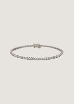 Popularized by famous tennis player Chris Evert in 1987 during the US Championships, the tennis bracelet is a timeless classic—then, now, always.Featuring 1.5mm round diamonds, four-prong cupcake set in 14k yellow or white gold. Wear alone or stacked with our Capri Curb Chain Bracelet. Designed and created in Los Angeles with ethically and sustainably sourced diamonds.Price is determined by bracelet length due to diamond quantity.Features a box clasp with safety for secure closure. The white gol Timeless Diamond Tennis Bracelet With Round Cut, Timeless Diamond White Tennis Bracelet With Round Cut, Timeless Diamond Tennis Bracelet, Timeless Round Cut Diamond Tennis Bracelet, Timeless Round Tennis Bracelet With Diamond Accents, Classic Diamond Tennis Bracelet With Accents, Classic Tennis Bracelet In Diamond White With Diamond Cut, Classic Diamond White Tennis Bracelet, Platinum Round Tennis Bracelet With Prong Setting