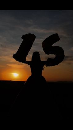 the silhouette of a woman with her arms in the air and number six over her head