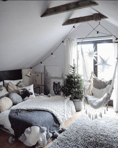 a bedroom with hammock hanging from the ceiling and pillows on the bedspread