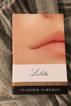 a book with an image of a woman's lips on it sitting on a bed