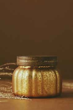 a golden jar sitting on top of a wooden table