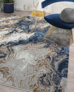 a blue chair sitting on top of a rug next to a white and gray area rug