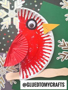 a paper plate with a red bird on it and snowflakes in the background