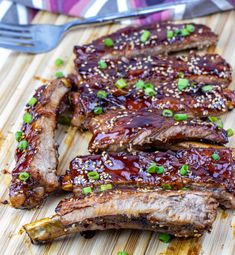 ribs with sesame seeds and green onions on a cutting board