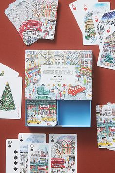 playing cards are laid out on a red surface, with christmas scenes painted all over them