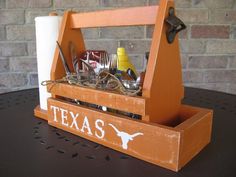 a wooden utensil caddy with texas on the side and other utensils in it