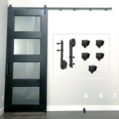 an open door and some black brackets in front of a white wall with glass doors