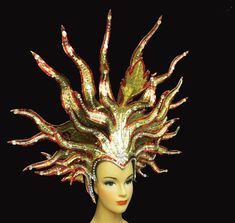 a mannequin wearing a gold and red headdress with fire flames on it