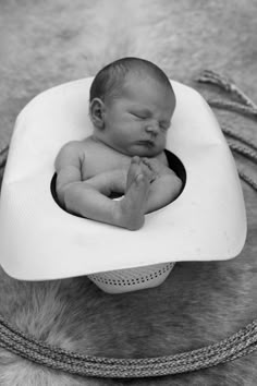 a baby is laying down in a hat