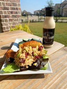 there is a sandwich and salad on the table next to a bottle of ketchup