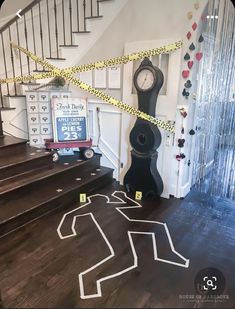 there is a clock on the floor next to some stairs with caution tape around it