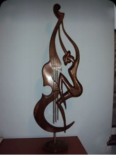 a wooden sculpture with an abstract design on it's body and two strings in the shape of a woman