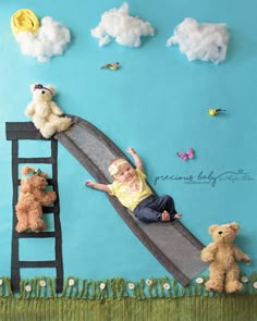 a baby laying on top of a fake slide with stuffed animals around it and clouds in the background