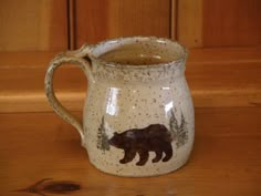 a ceramic bear mug sitting on top of a wooden table