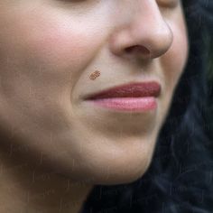 a close up of a woman with nose piercings on her nose, looking to the side