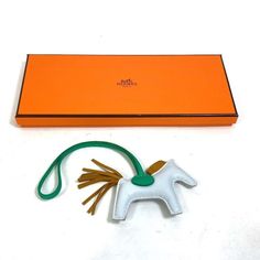 an orange box with a small white horse on it's side next to a green string