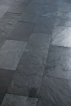 a black and white photo of a tile floor with grey tiles on the bottom half