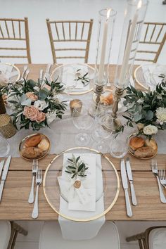 the table is set with silverware and flowers