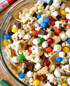 a bowl filled with popcorn and m & m's on top of a table