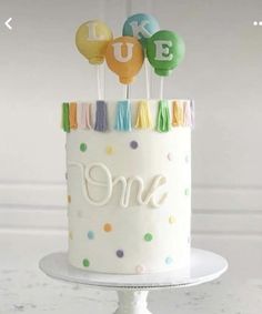 a birthday cake decorated with balloons and the number one