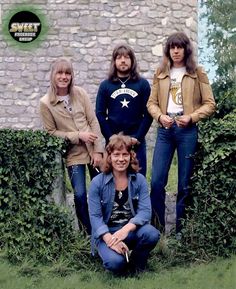 the doors posing for a photo in front of an old brick building with ivy growing around it