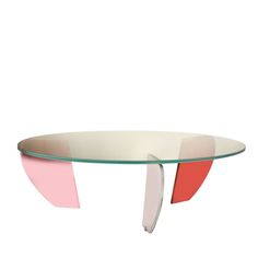 an oval glass table with pink, red and white shapes on the top is against a white background