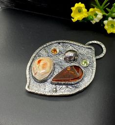 Artisan Amber with Mexican Fire Opal pendant in sterling silver  Hand-made Sterling Silver 925  Stones used: Baltic Amber, Mexican Fire Opal Purple Pearl,   Peridot, Citrine   Height - 2”, Width – 1 3/8” Unique Handcrafted One-of a-kind Design PendantEach Piece of Jewelry in my Collection is Absolutely One of a Kind!When you start wearing a piece of my jewelry you will fall in love with it more and more each day and feel that good Energy and Love that I pass into it while creating this piece of Artisan Sterling Silver Pendant Gemstones, Silver Cabochon Pendant Gemstone, Silver Cabochon Gemstone Pendant, Silver Multi-stone Pendant Gemstones, Artisan Silver Pendant Gemstones, Sterling Silver Multi-stone Pendant Gemstones, Unique Sterling Silver Pendant Gemstones, Sterling Silver Multi-stone Pendant, Cabochon Pendant Gemstones For Jewelry Making