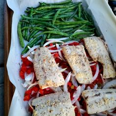 fish, green beans and onions are on a tray with some seasoning in it