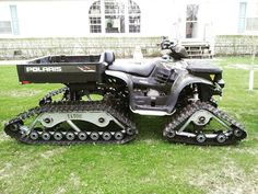 an atv is parked in the grass near a house