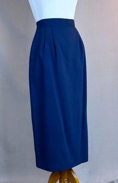 Very nice midi length skirt from the 80s. Fabric is 50% rayon, 50% polyester in a solid navy blue.   *Back button and zipper closing  *Side seam pockets on each side *Front pleats on each side *Close back pleat with button tag *Completely lined Label is Michele, Made in the USA, Dry Clean Only. Tagged a size 8 but please use the measurements. *waist runs 26" *hips 38" *total length 31 1/2" *hem circumference 38" Alley Cats Vintage is a Member of the Vintage Fashion Guild. Alley Cats, Navy Blue Pencil Skirt, Blue Pencil Skirt, Midi Length Skirts, Midi Length, Pencil Skirt, Womens Skirt, Bathing Beauties, Vintage Fashion