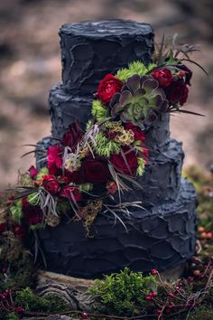 a three tiered cake decorated with flowers and succulents