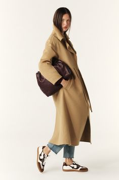 The ba&sh KATE coat is a key piece this season. This long coat has minimalist style, a shirt collar, slightly dropped shoulders, and piped pockets. It hits below the knees. It's made in a double-sided wool cloth  and it has a tie belt in the same fabric that slips through golden grommets at the waist. A coat with chic and streamlined style that's enhanced with a pretty feminine detail. This piece is crafted with LENZING ECOVERO viscose, a fiber made from wood pulp sourced from sustainably manage Woollen Fabric, Kate Brown, Cord Belt, Skirt And Sneakers, Scarf Top, Favorite Daughter, Notched Collar, Boho Vibe, Ulla Johnson