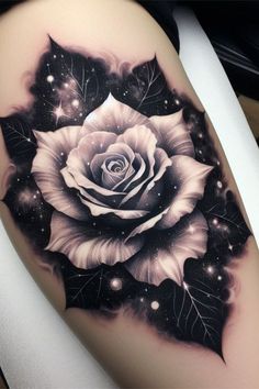 a black and white rose tattoo on the right thigh, with stars in the background