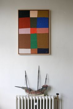 a painting hanging on the wall next to a radiator with two scissors in it