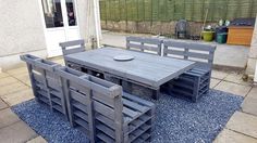 an outdoor table and chairs made out of pallet wood, sitting on a patio