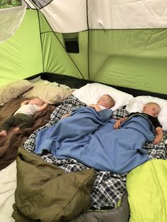 two babies are sleeping in a tent on the bed with their blankets folded over them