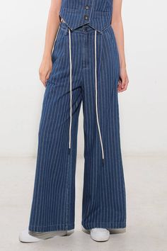 A striped denim pant featuring high waist, front closure, side pockets, contrasting belt and wide leg. Matching vest FJ1094 Details: Self : 100% Cotton Size & Fit - Model is 5`9" And Wearing Size Small- Measurements Taken From Size Small- Approx. Length: 42 1/2"- Approx. Inseam: 30" Wide Leg Vertical Stripes Jeans For Spring, Casual Wide Leg Jeans With Vertical Stripes, Casual High Rise Pants With Vertical Stripes, Striped Cotton Jeans For Workwear, Striped Straight Leg Jeans For Work, Trendy Denim Bottoms With Vertical Stripes, Striped Jeans For Work And Spring Season, Spring Striped Jeans For Work, Wide Leg Denim Bottoms With Vertical Stripes