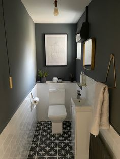 a white toilet sitting in a bathroom next to a sink