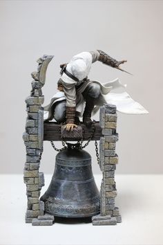 a figurine sitting on top of a bell