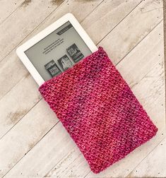 an electronic device sitting on top of a wooden floor next to a pink cloth covered case